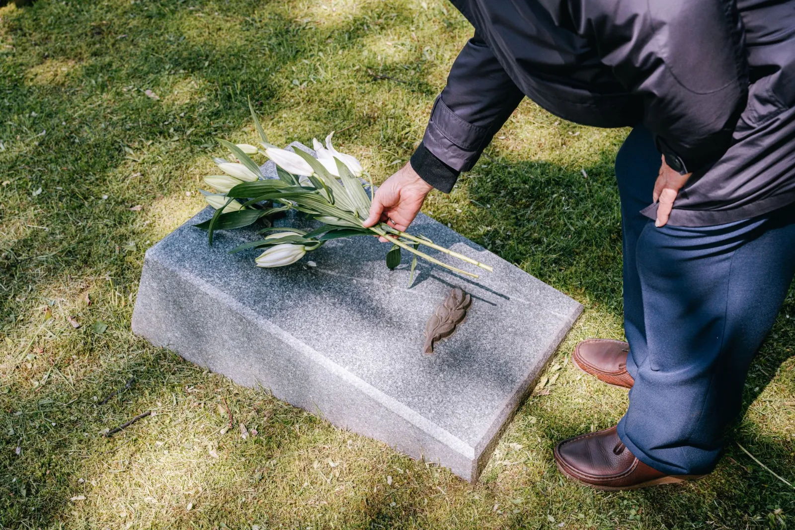 Dépôt de fleurs sur une sépulture après son nettoyage